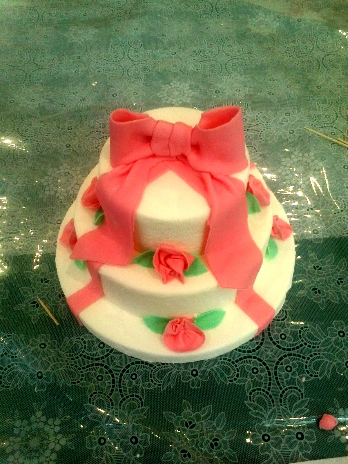 Wedding cake bianca decorata con pasta di zucchero, fiocco e roselline rosa